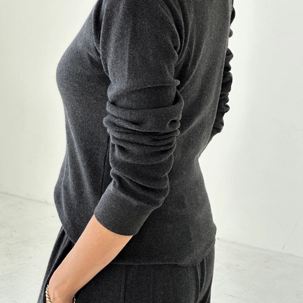 
                  
                    Person wearing a dark gray long sleeve and pants on a light background
                  
                