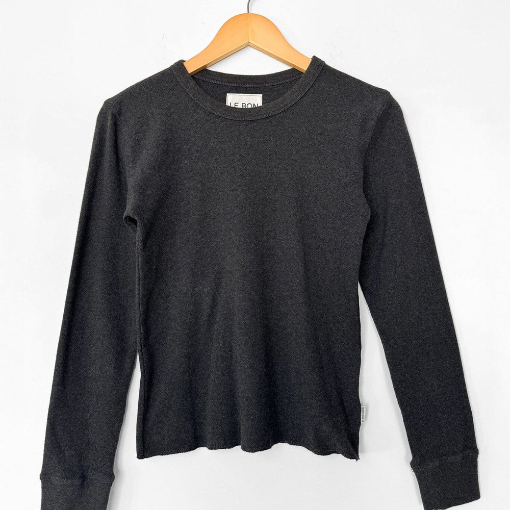 Black long-sleeve shirt on a wooden hanger against a white background