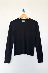 Black long-sleeve shirt on a wooden hanger against a white background