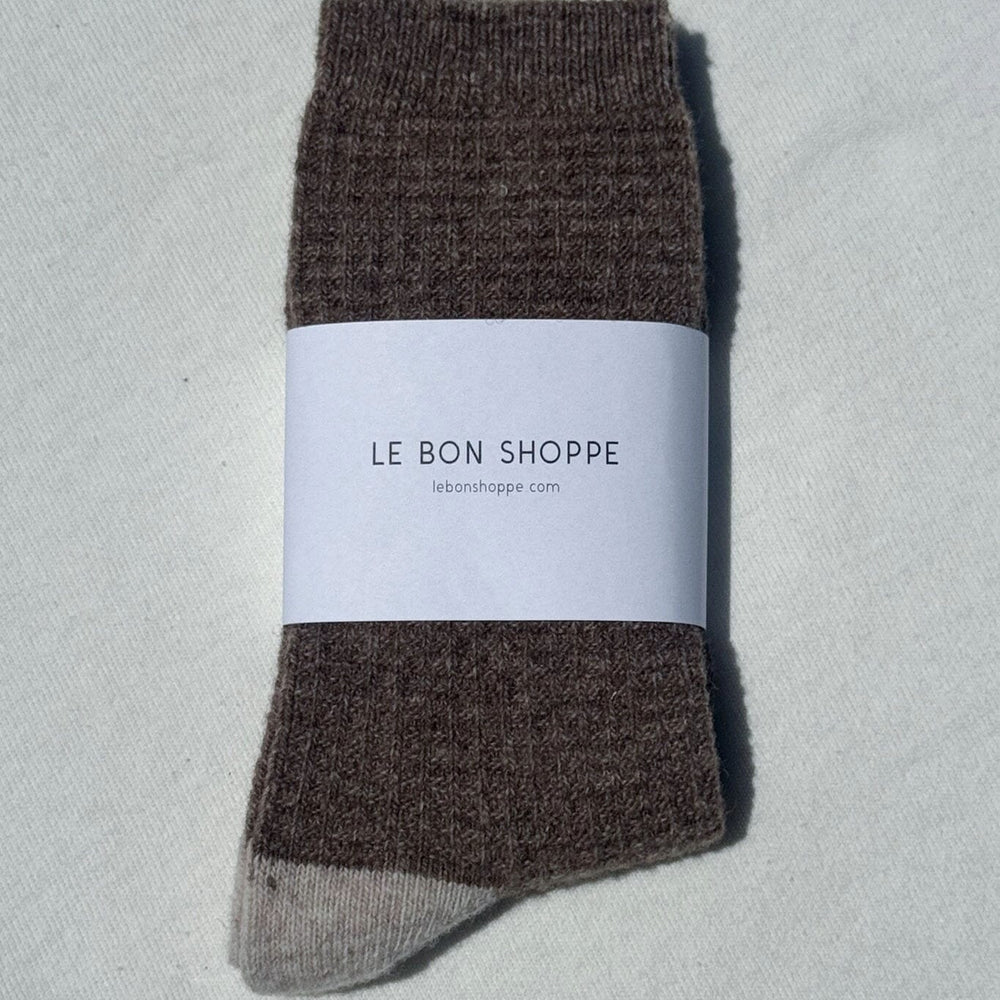 
                  
                    Brown socks with a white label on a light gray background
                  
                
