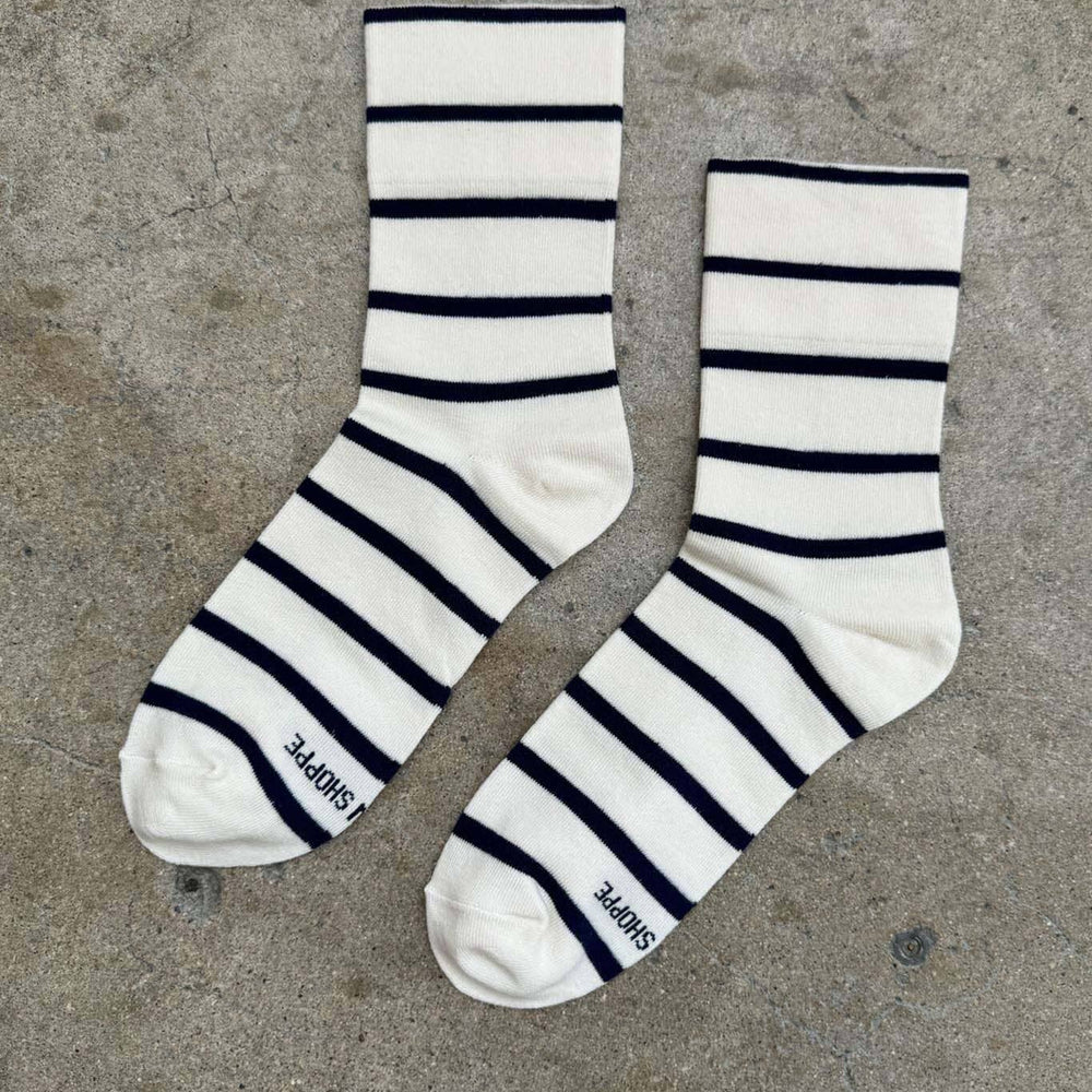 Pair of black and white striped socks on a concrete surface