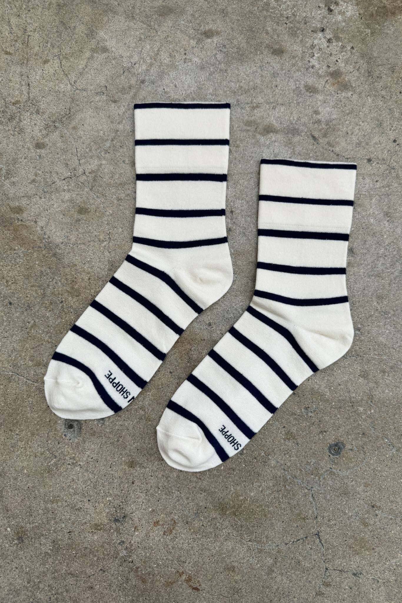 Pair of black and white striped socks on a concrete surface