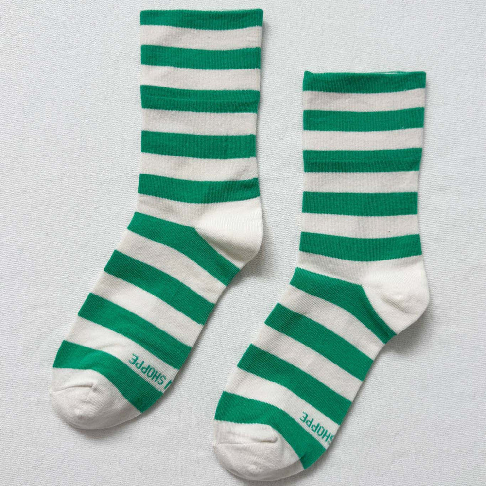 Green and white striped socks on a light gray background