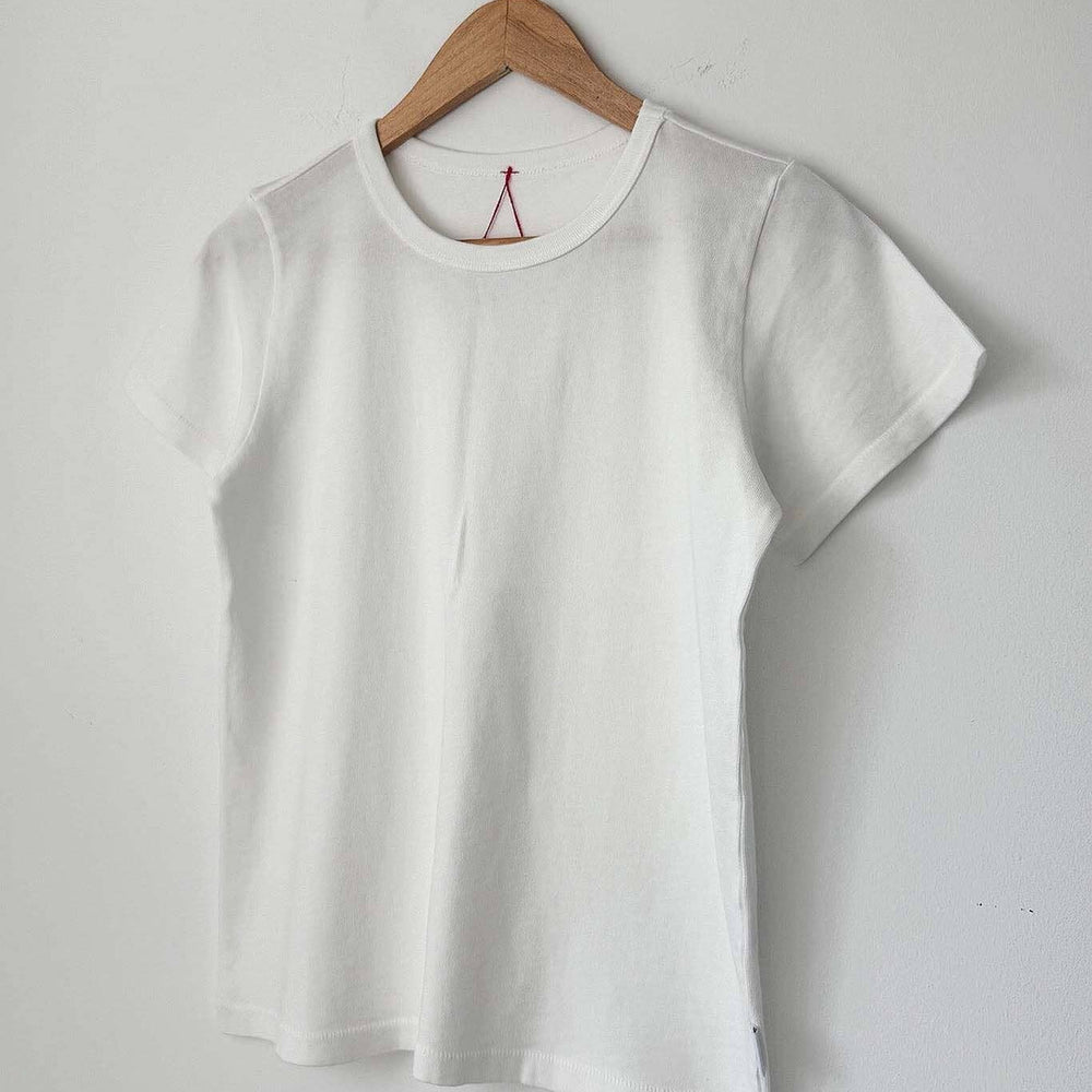 White t-shirt on a wooden hanger against a plain background