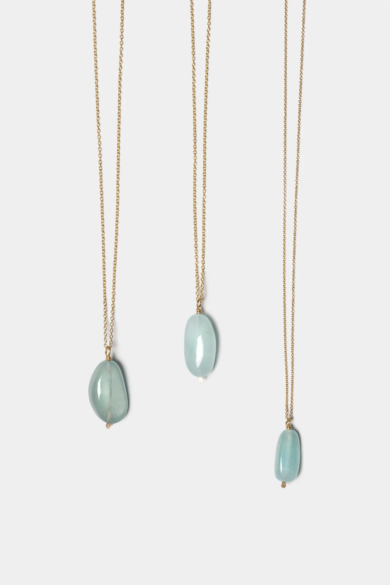 Three necklaces with green aqua pendant stones on a white background