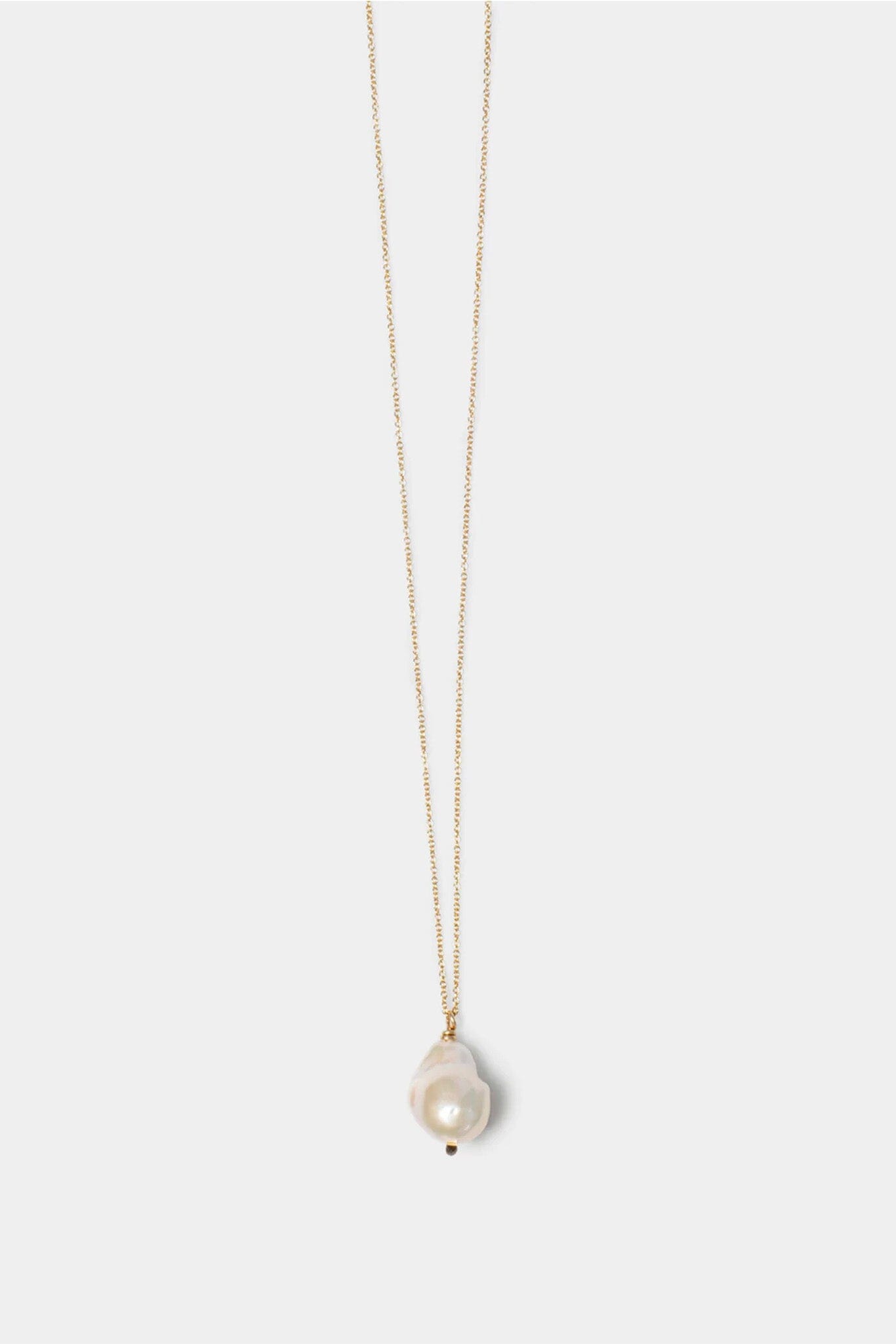 Pearl necklace on a thin gold chain against a white background
