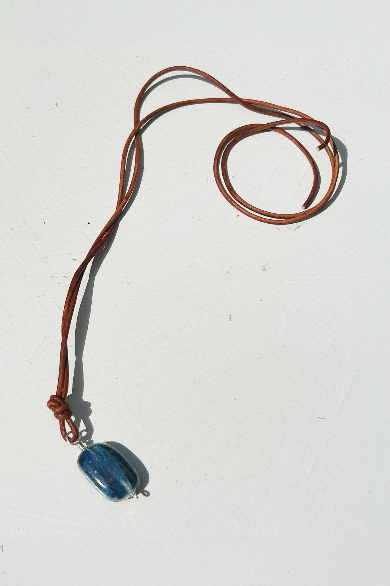Necklace with a small, blue kyanite pendant on a white background