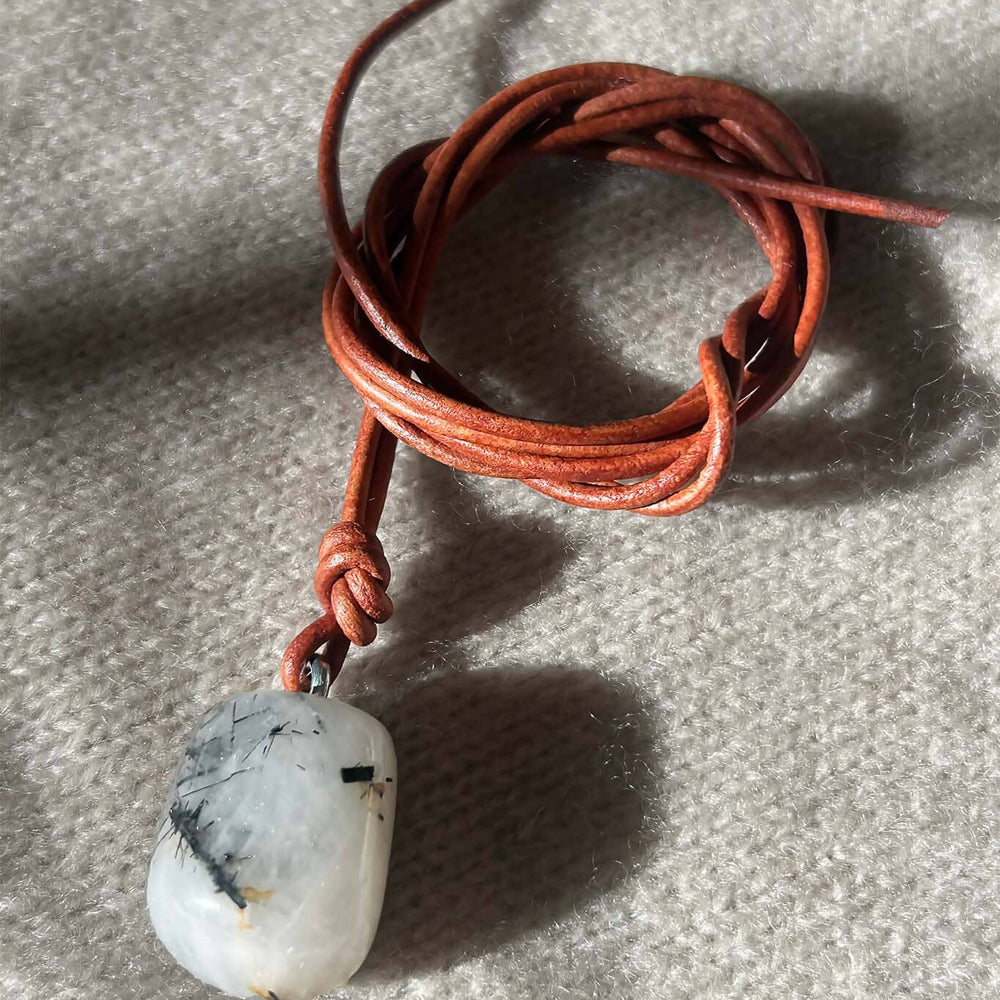Necklace with a white and black stone pendant on a textured surface