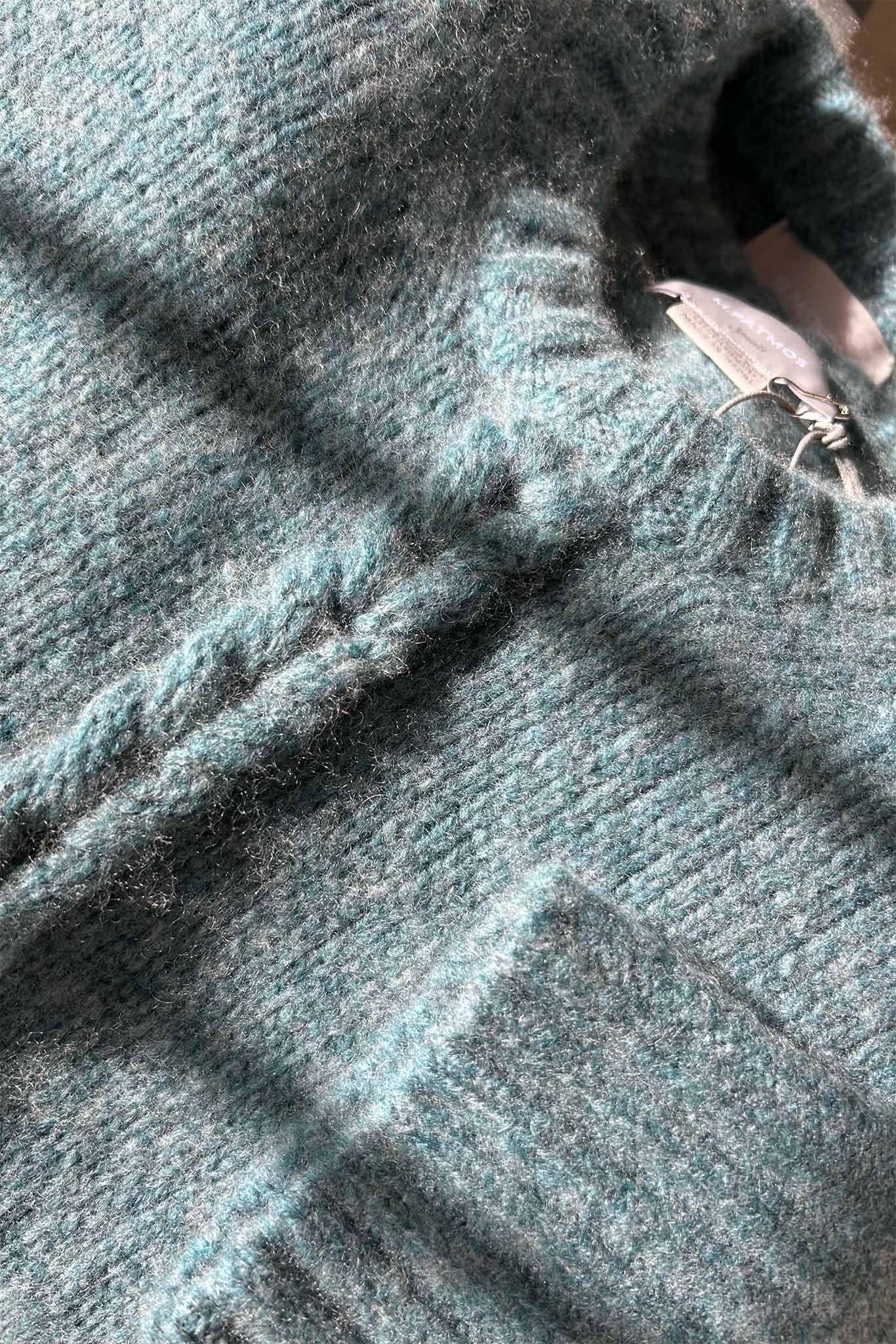 A close up of the Mies cashmere and merino wool sweater in a mineral green color