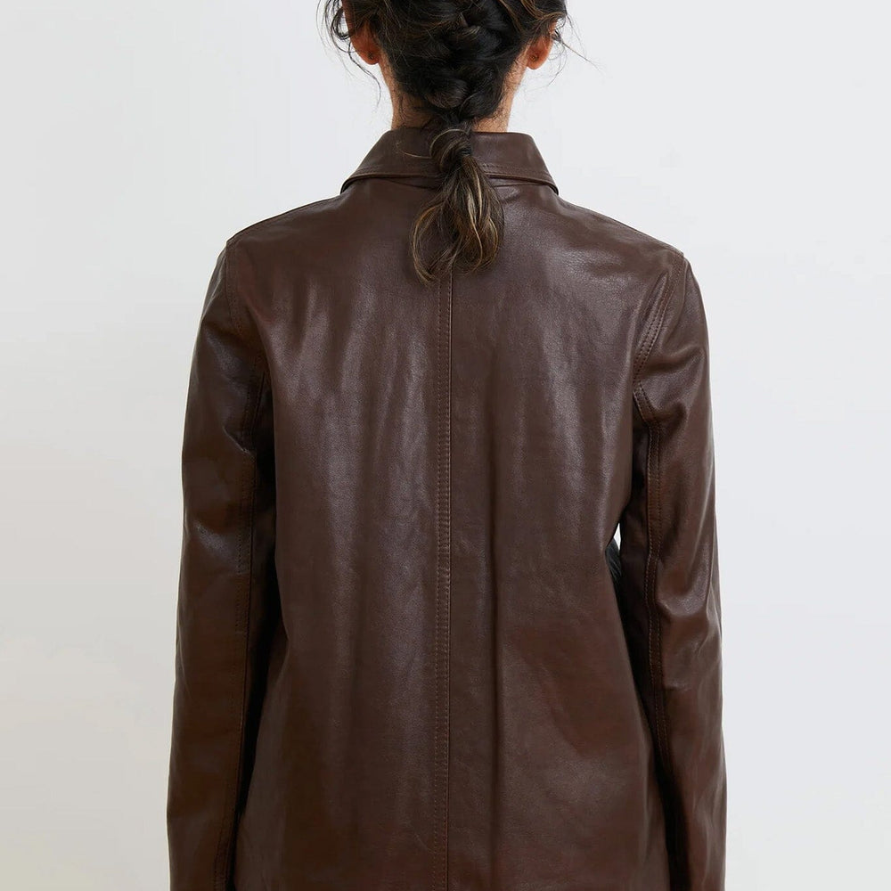 Brown leather jacket worn by a person on a white background