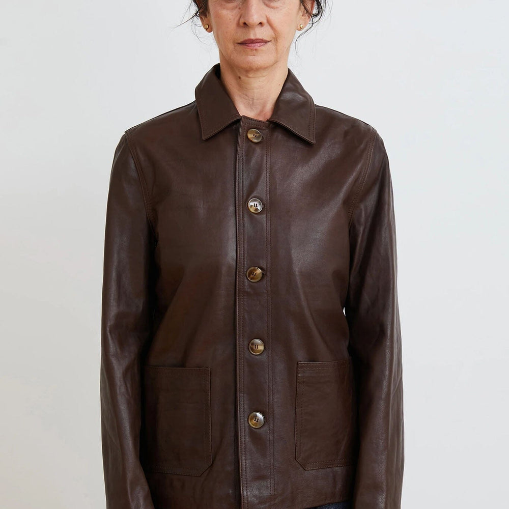 Woman wearing a brown leather jacket on a plain background