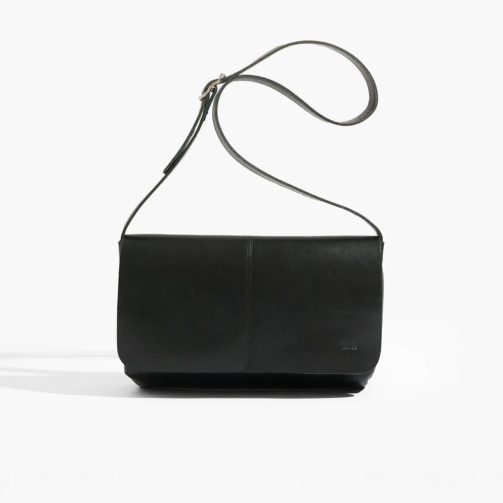 Black leather handbag with a strap on a white background