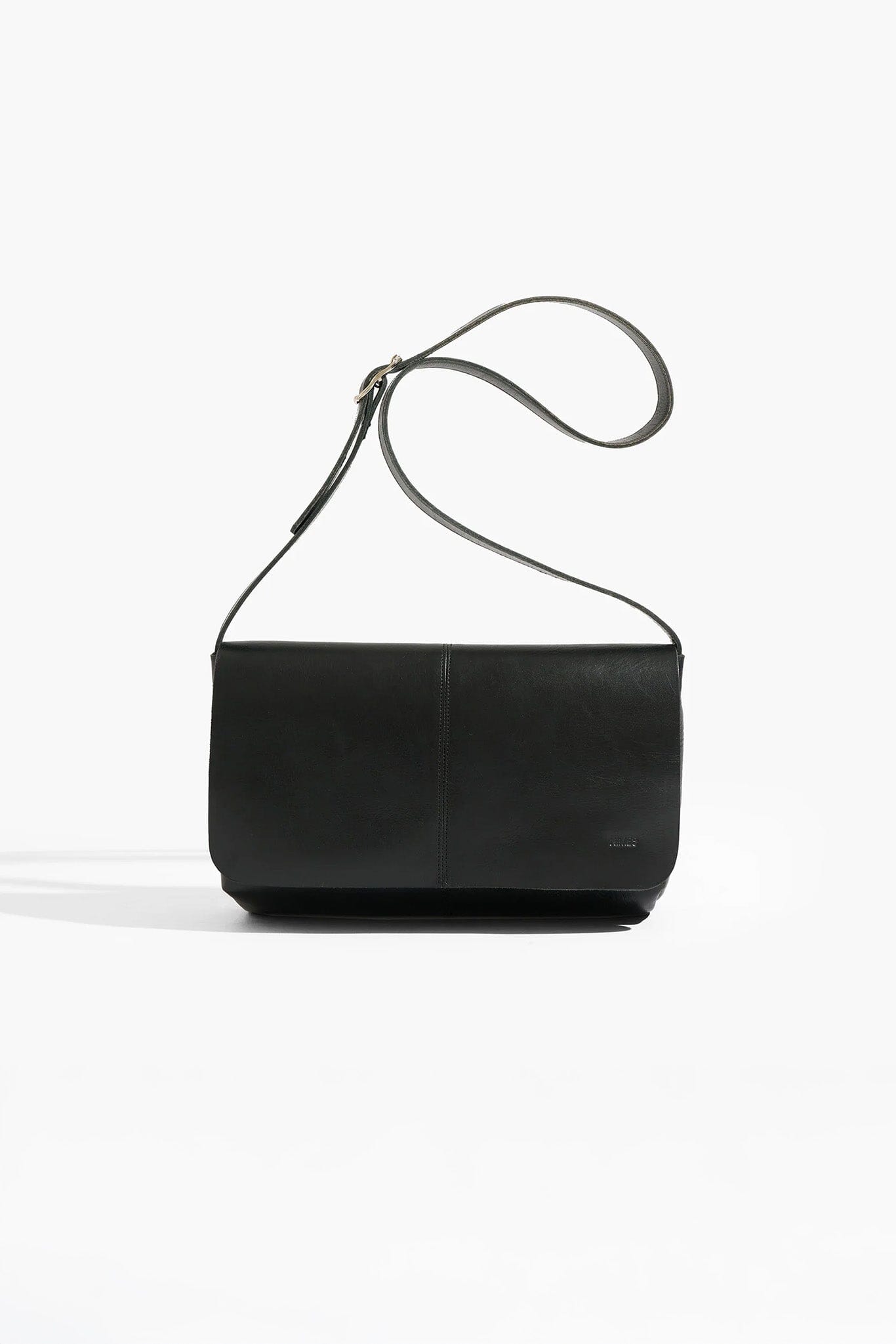 Black leather handbag with a strap on a white background