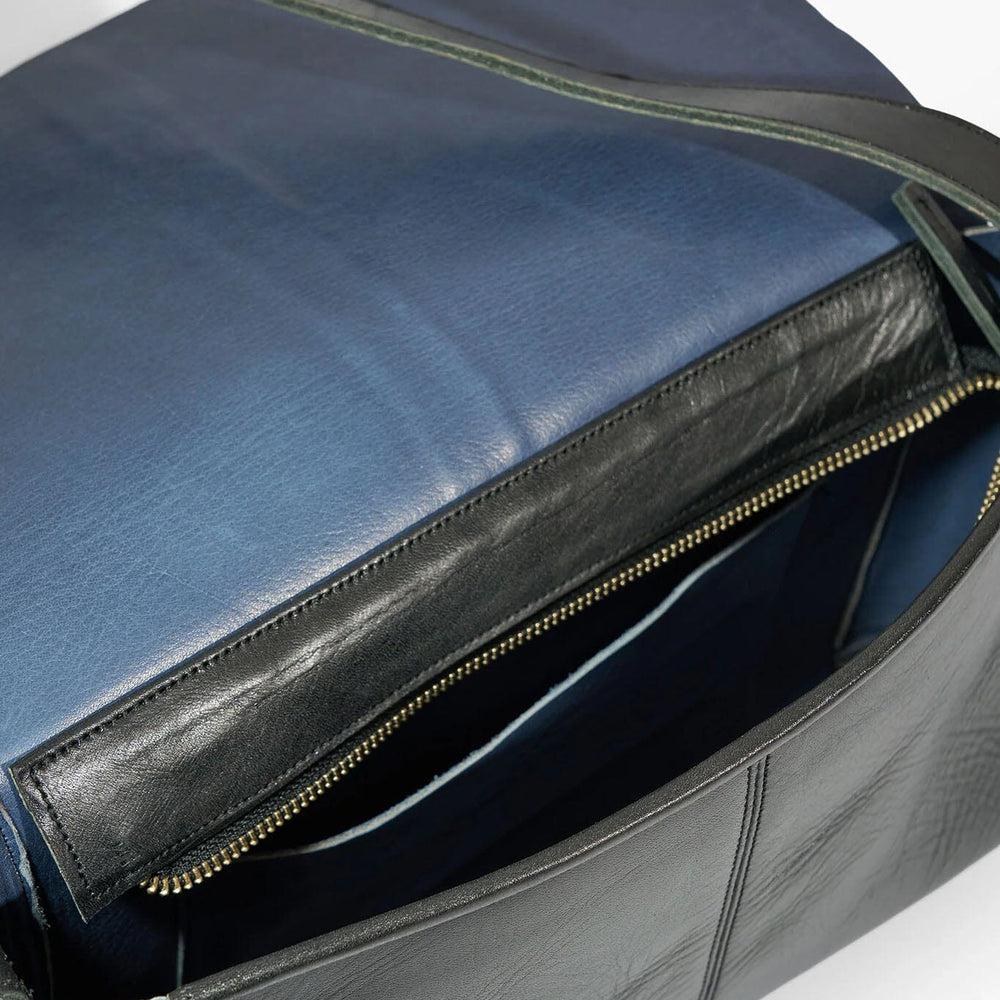 
                  
                    Black leather bag with a gold zipper on a white background
                  
                