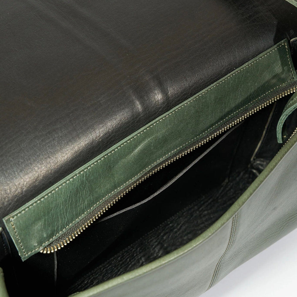 
                  
                    Green leather bag with a black interior on a white background
                  
                