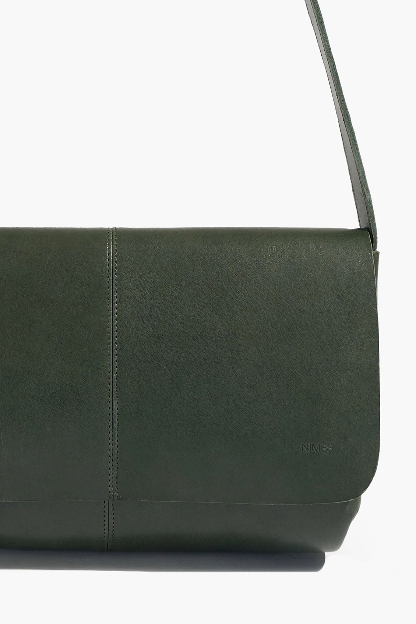 Green leather bag with a strap on a white background