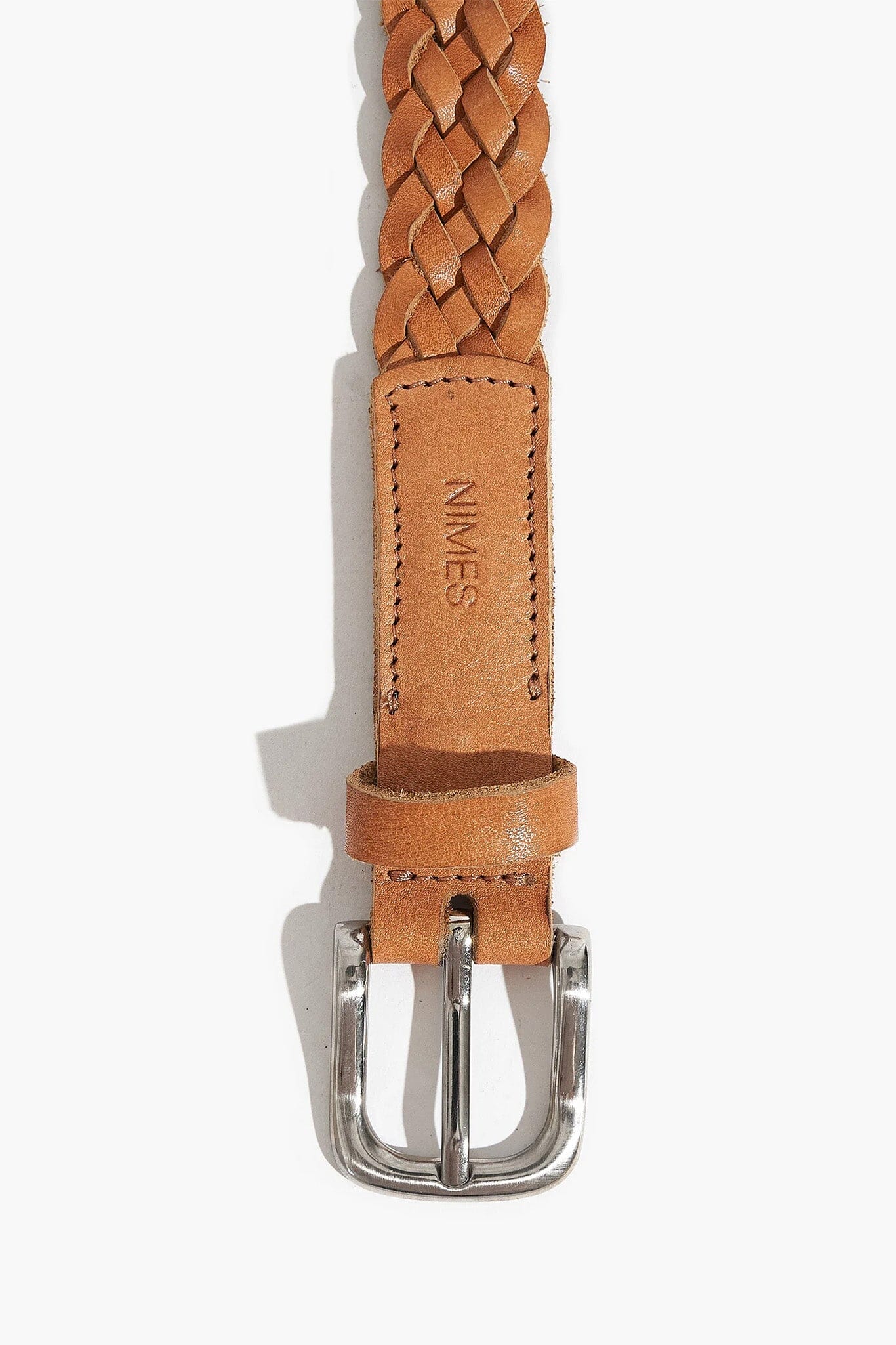 Brown braided leather belt with silver buckle on a white background