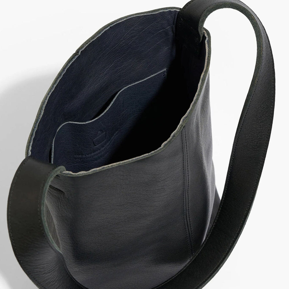 Black leather handbag with a strap on a white background