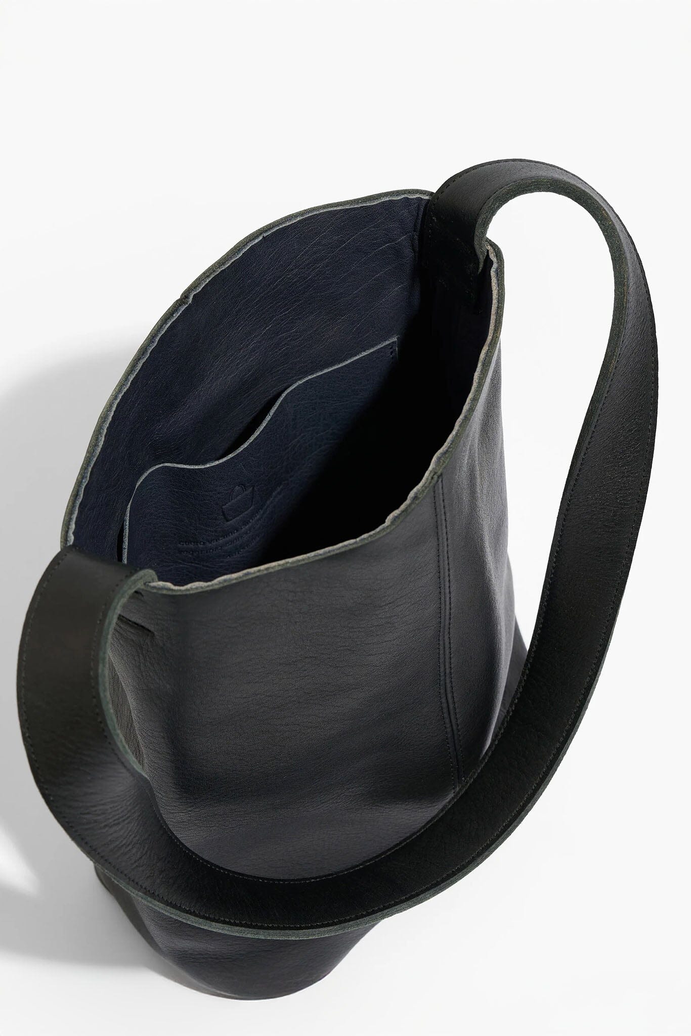 Black leather handbag with a strap on a white background