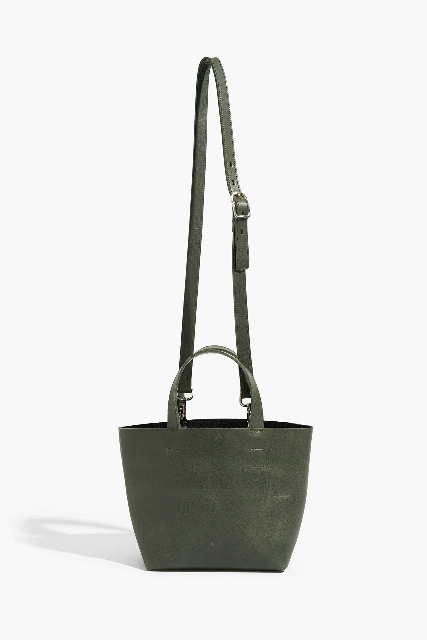 Green tote bag with a long strap on a white background