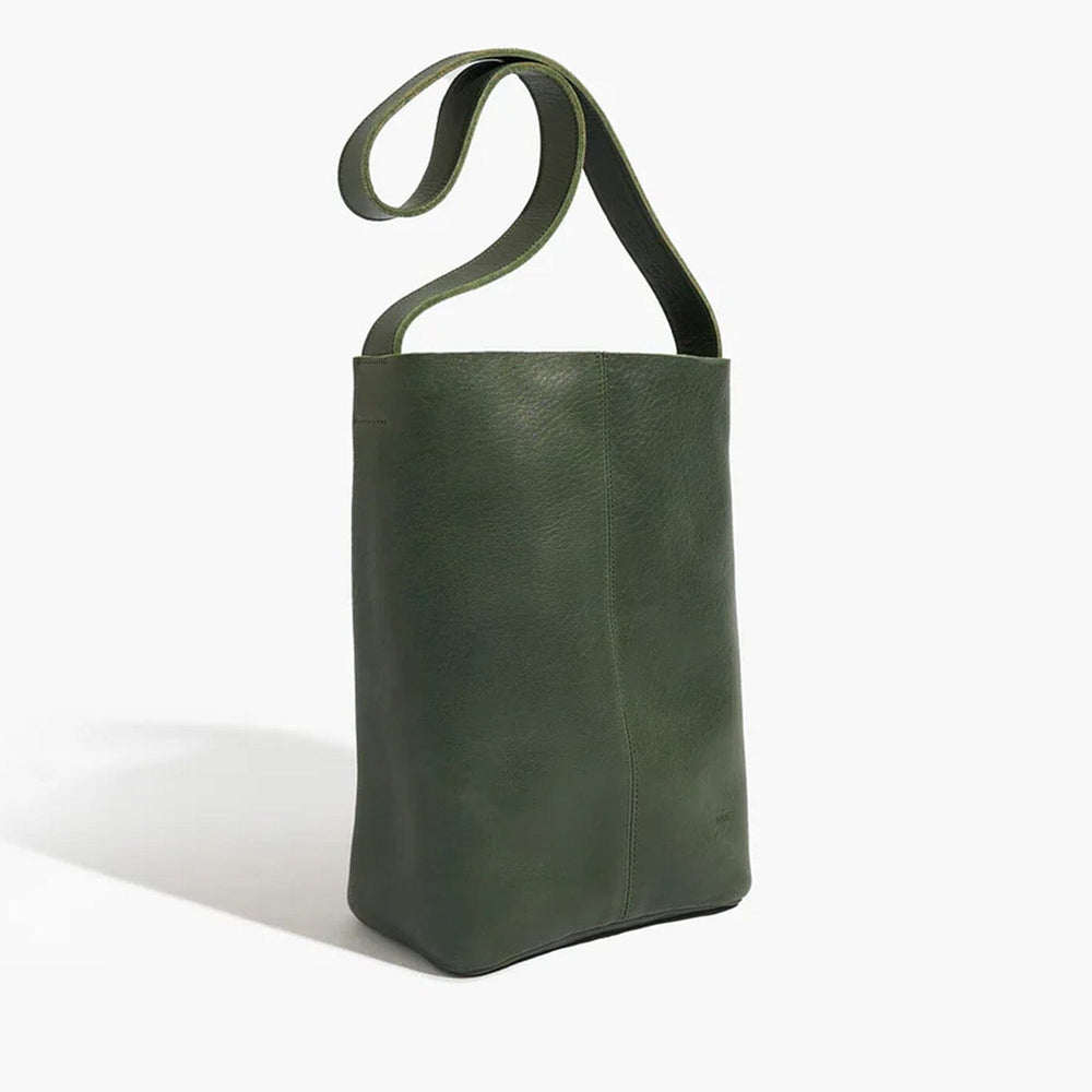 Green leather bag with a wide shoulder strap on a white background