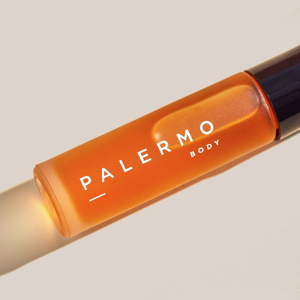 Orange rollerball with 'Palermo Body' branding on a beige background