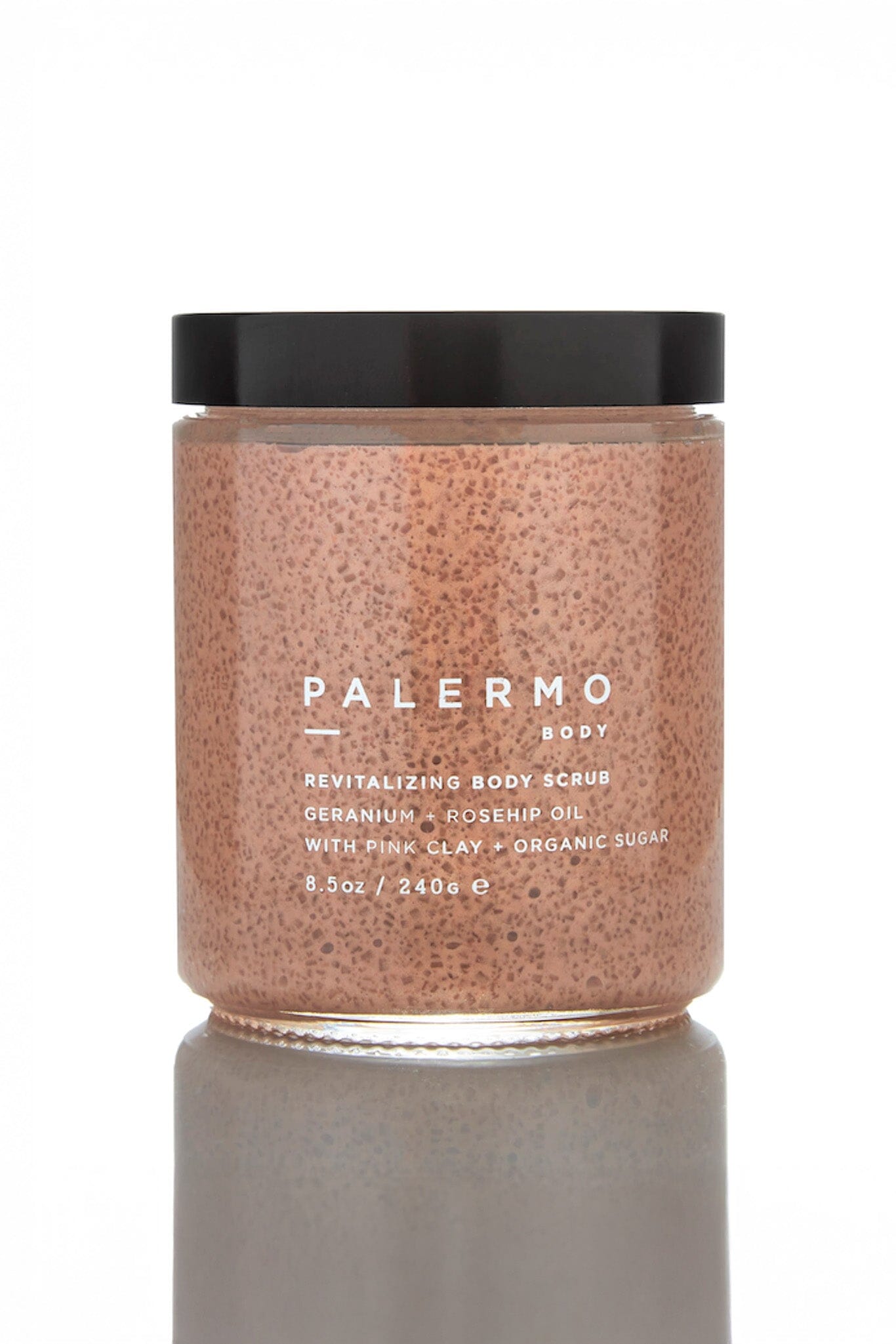 A clear jar containing a pinkish body scrub with exfoliants, labeled 'PALERMO BODY' on the front.