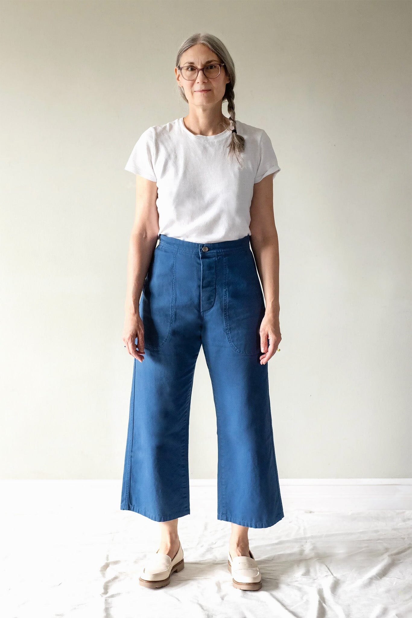 Person wearing a white t-shirt and blue jeans against a plain background
