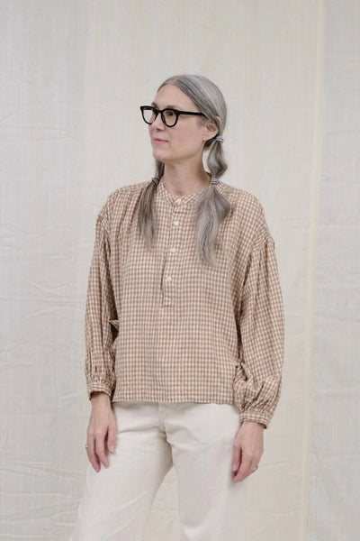 Cotton long sleeve peasant blouse featuring a brown gingham pattern. Designed by Uqnatu, available to purchase at M.Patmos in Brooklyn, New York.