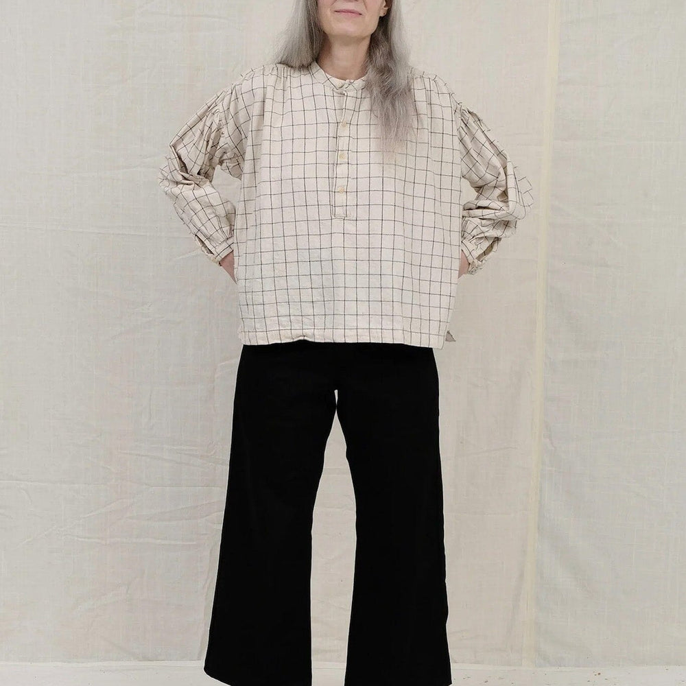 Cotton long sleeve natural peasant blouse featuring a black windowpane pattern. Designed by Uqnatu, available to purchase at M.Patmos in Brooklyn, New York.