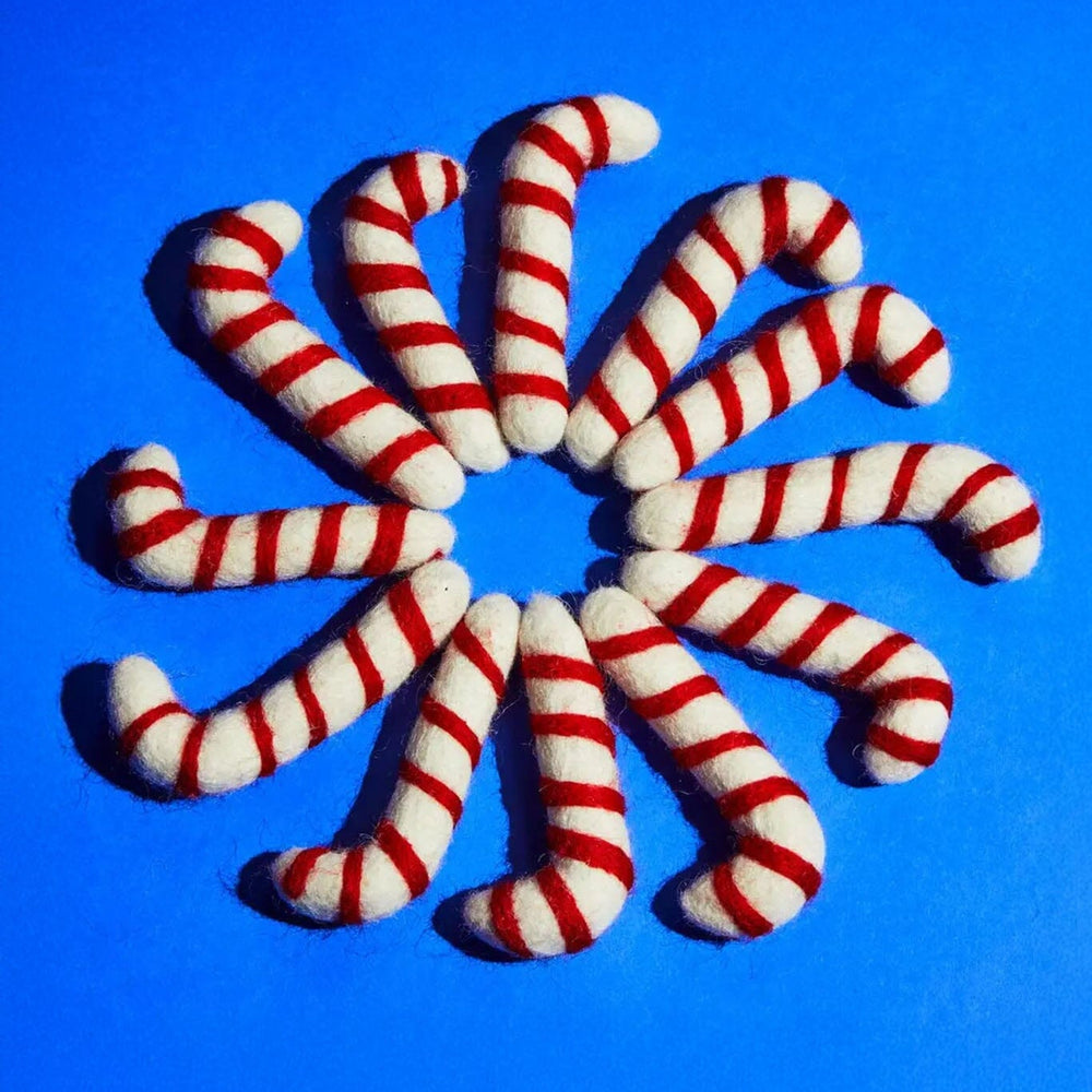 Red and white striped candy cane cat toys arranged in a circular pattern on a blue background