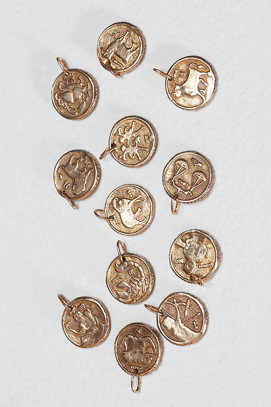 Brass zodiac charm coins by Alexis Laurel. Available to purchase at M.patmos.