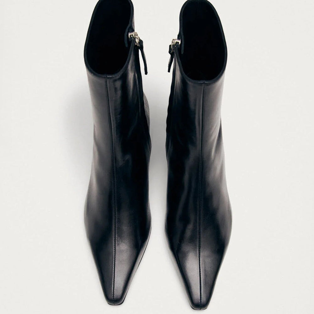 
                  
                    Pair of black pointed-toe boots on a white background
                  
                