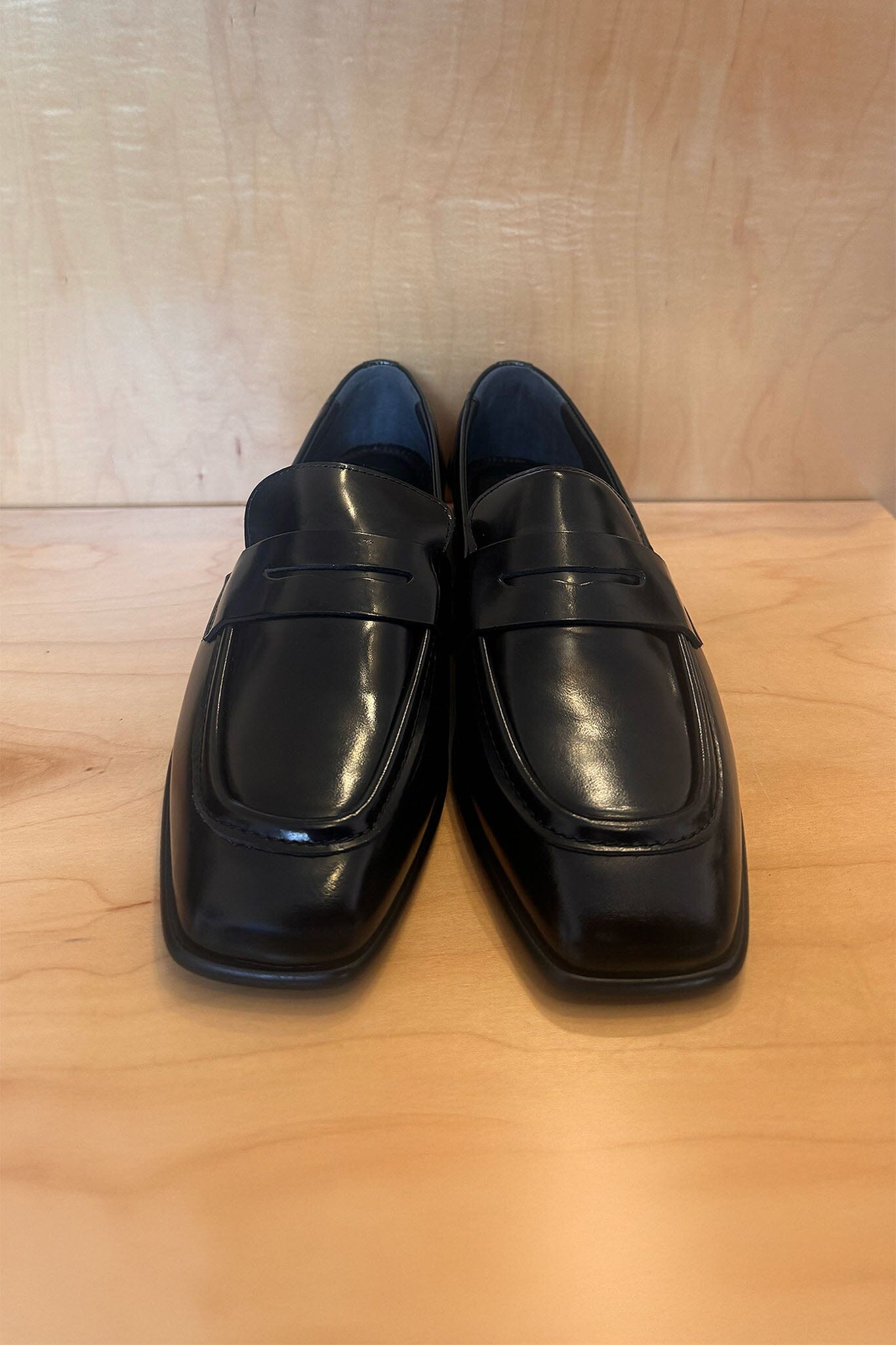 Pair of black loafers shoes on a wooden surface