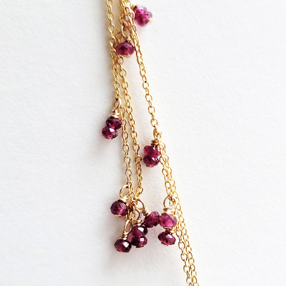 Dainty gold chain with ruby stones.