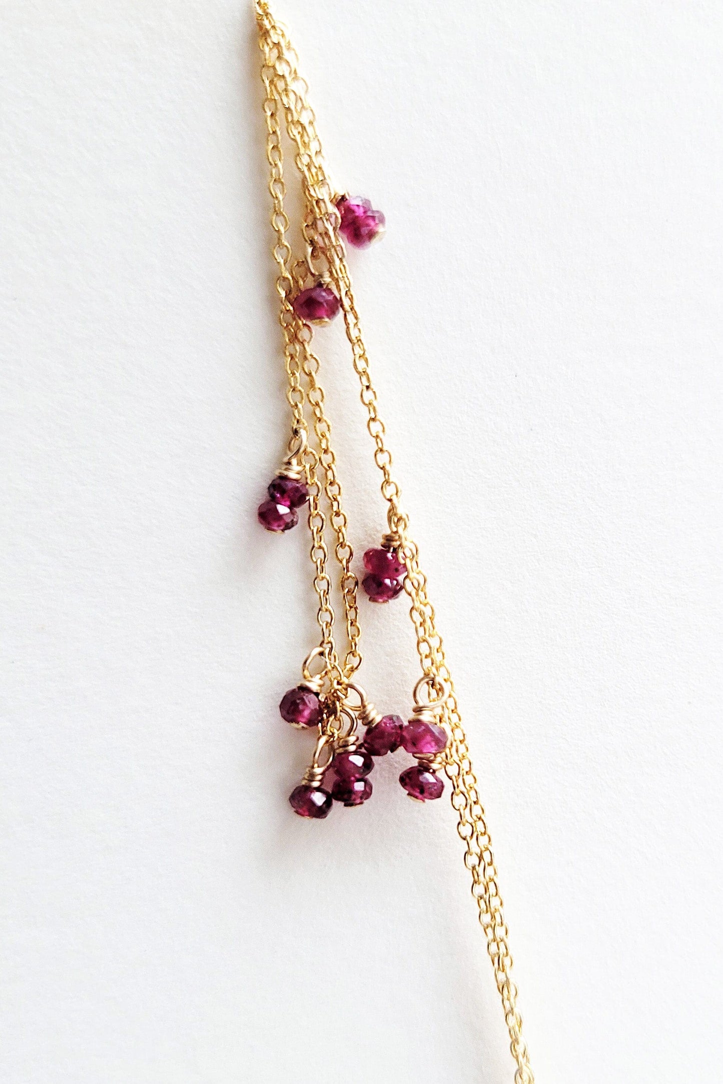 Dainty gold chain with ruby stones.