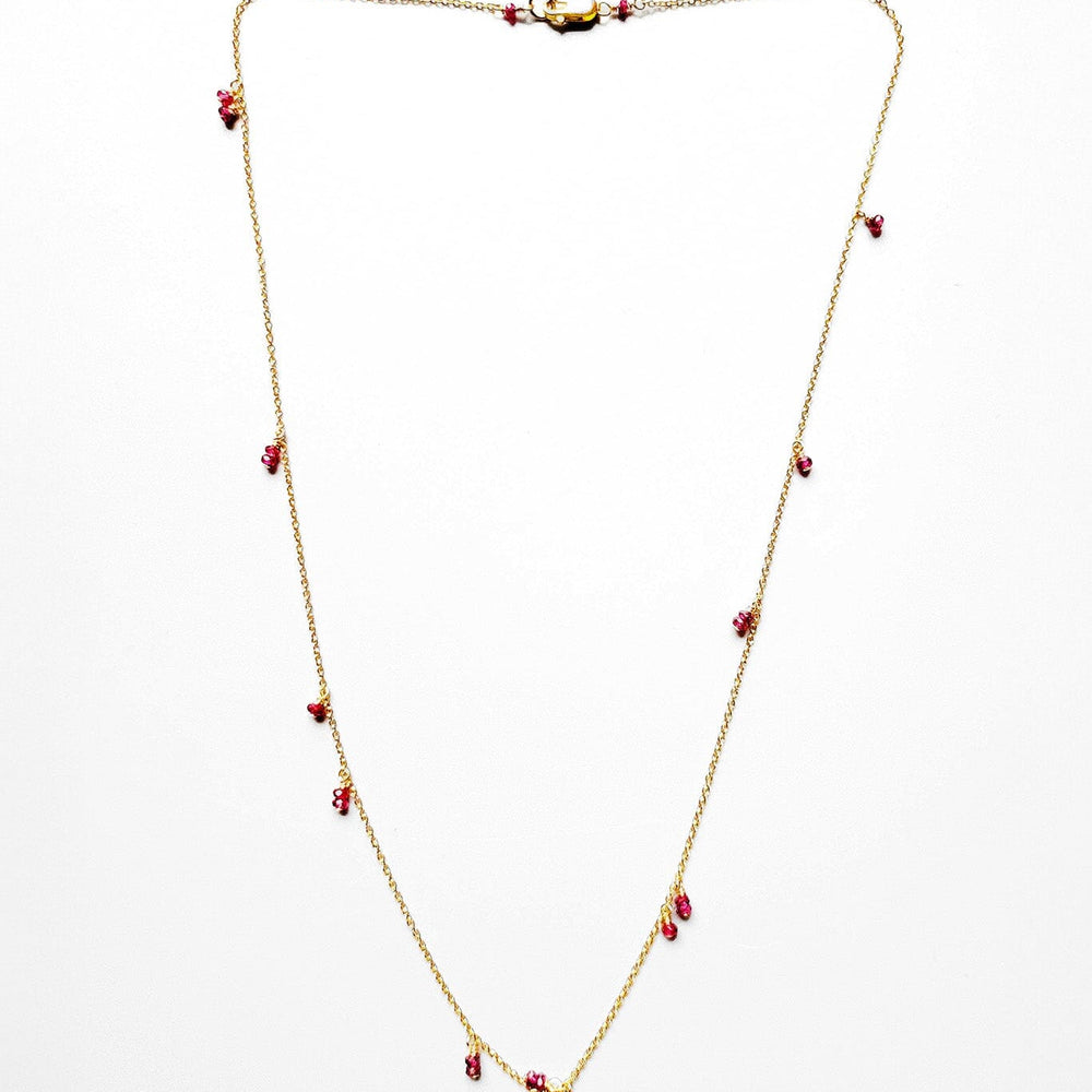 A delicate 14k gold filled chain necklace with cairn-like ruby briolettes on a white background.