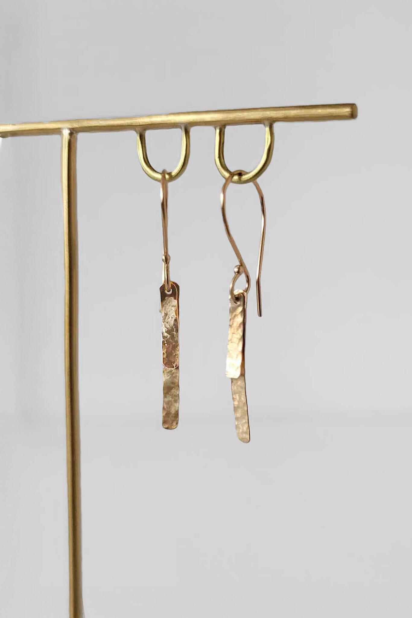 Minimalist 14k yellow gold hammered baguette earrings on gold ear wires. Handmade in Brooklyn.