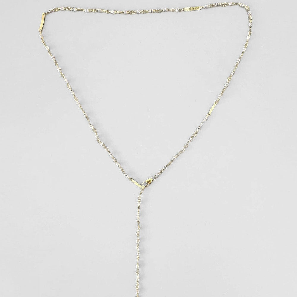 A gray handmade rosary-style necklace with 14k gold filled wire and clasp, natural pearls, and gold baguette elements, displayed against a white background.