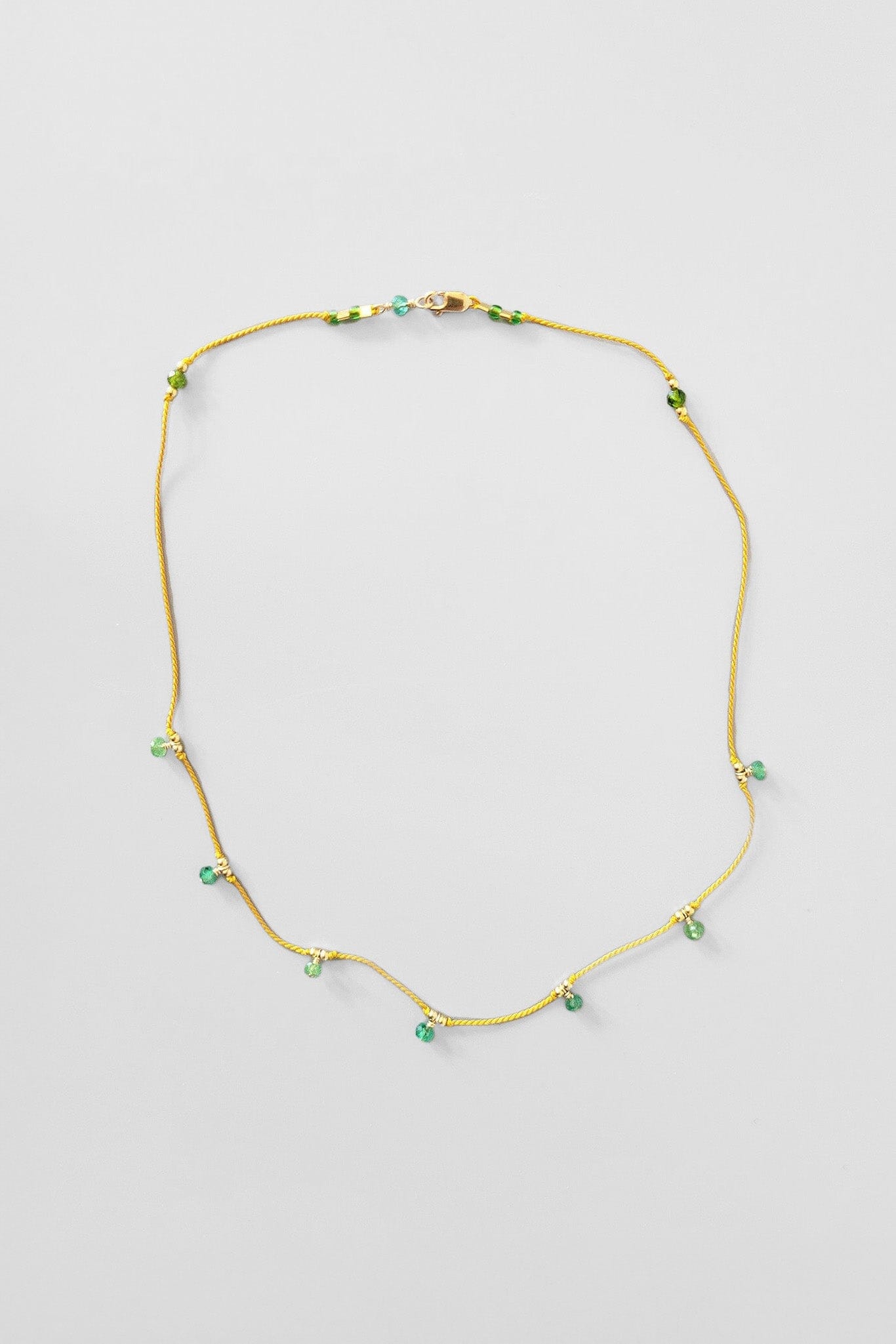 Handmade green gemstone necklace on yellow silk cord. 14k gold filled findings. Handmade by Cobamae in Brooklyn New York.