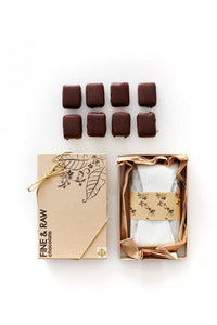 Box of fine and raw chocolate truffles on a white background