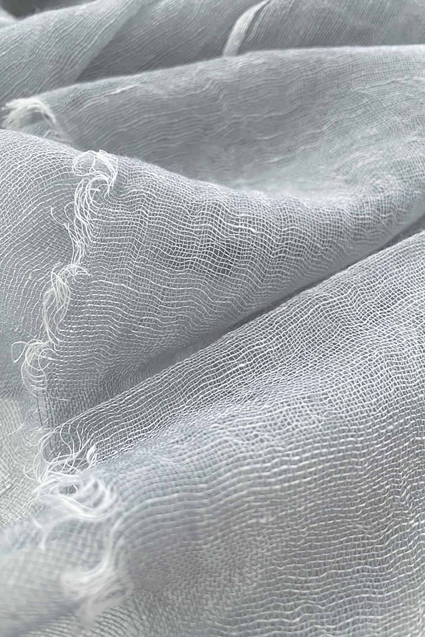 A close up shot of a silver handwoven scarf made of cashmere and linen
