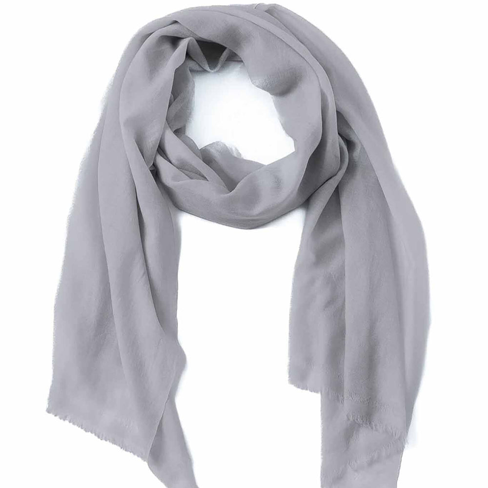 A gray cashmere and wool scarf draped and laid out on a plain background.