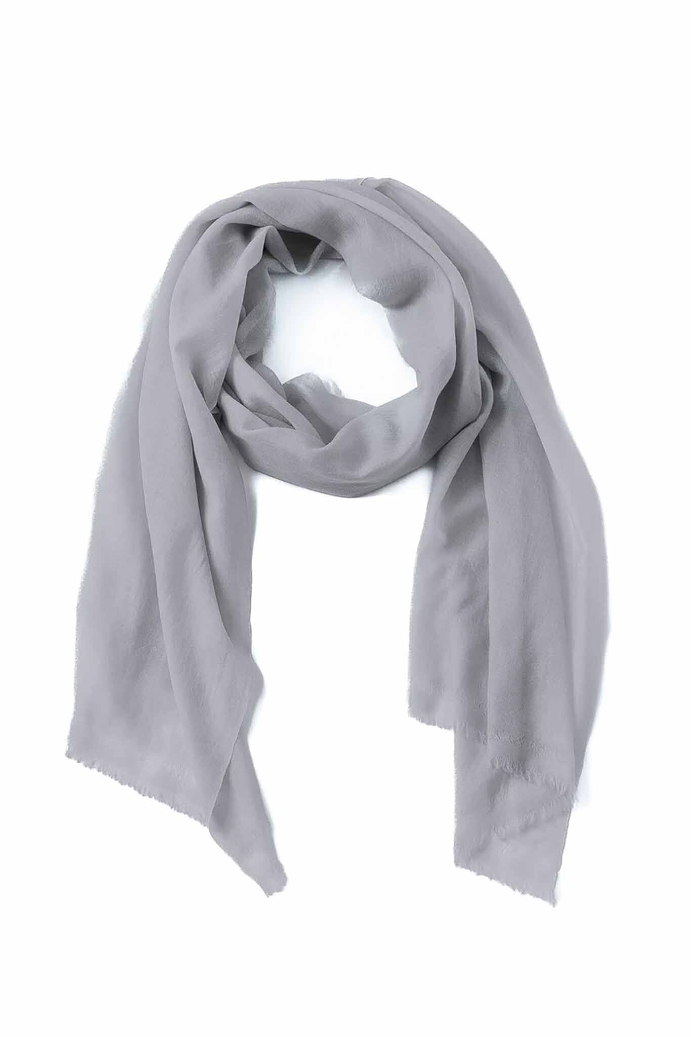 A gray cashmere and wool scarf draped and laid out on a plain background.