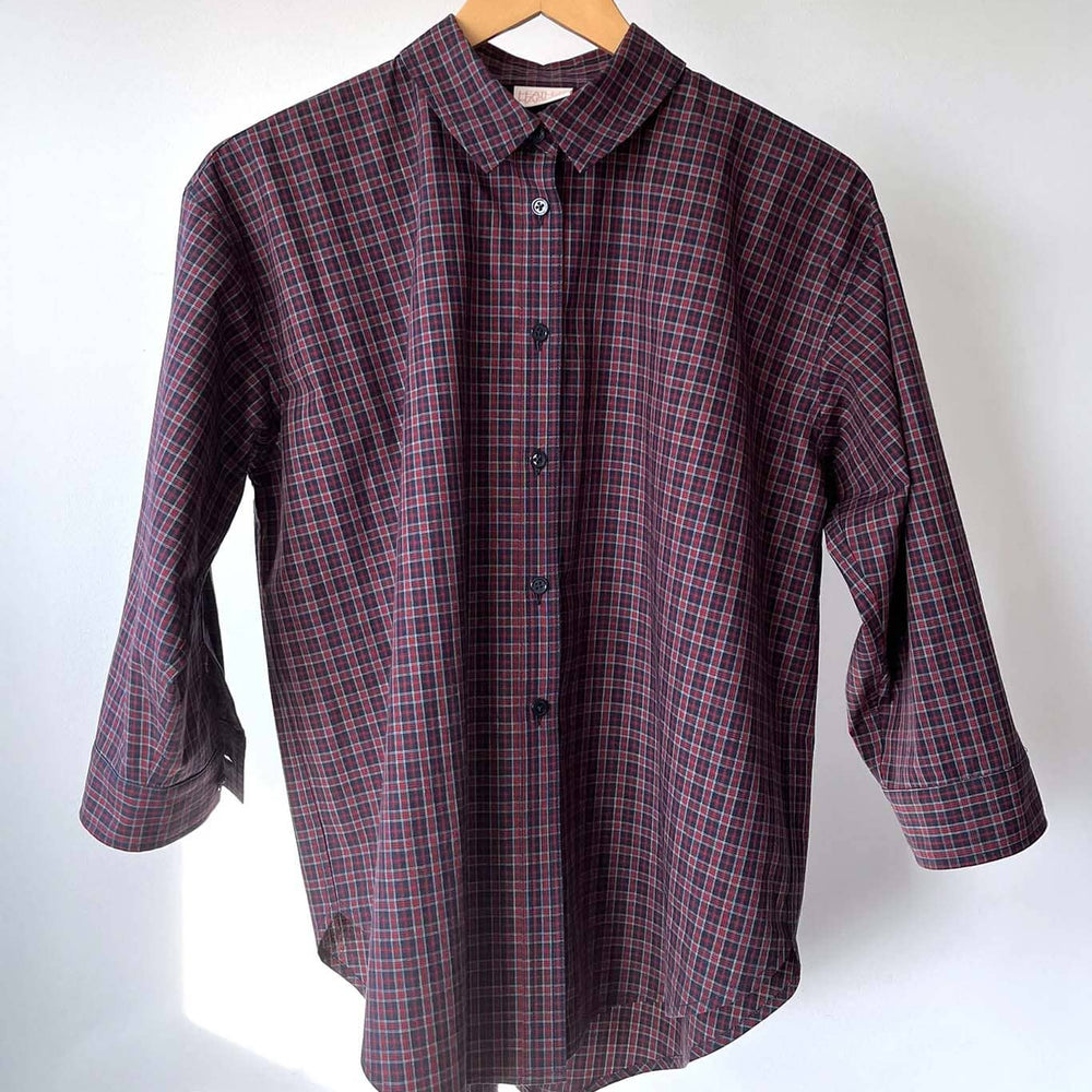 
                  
                    Plaid shirt on a hanger against a white background
                  
                