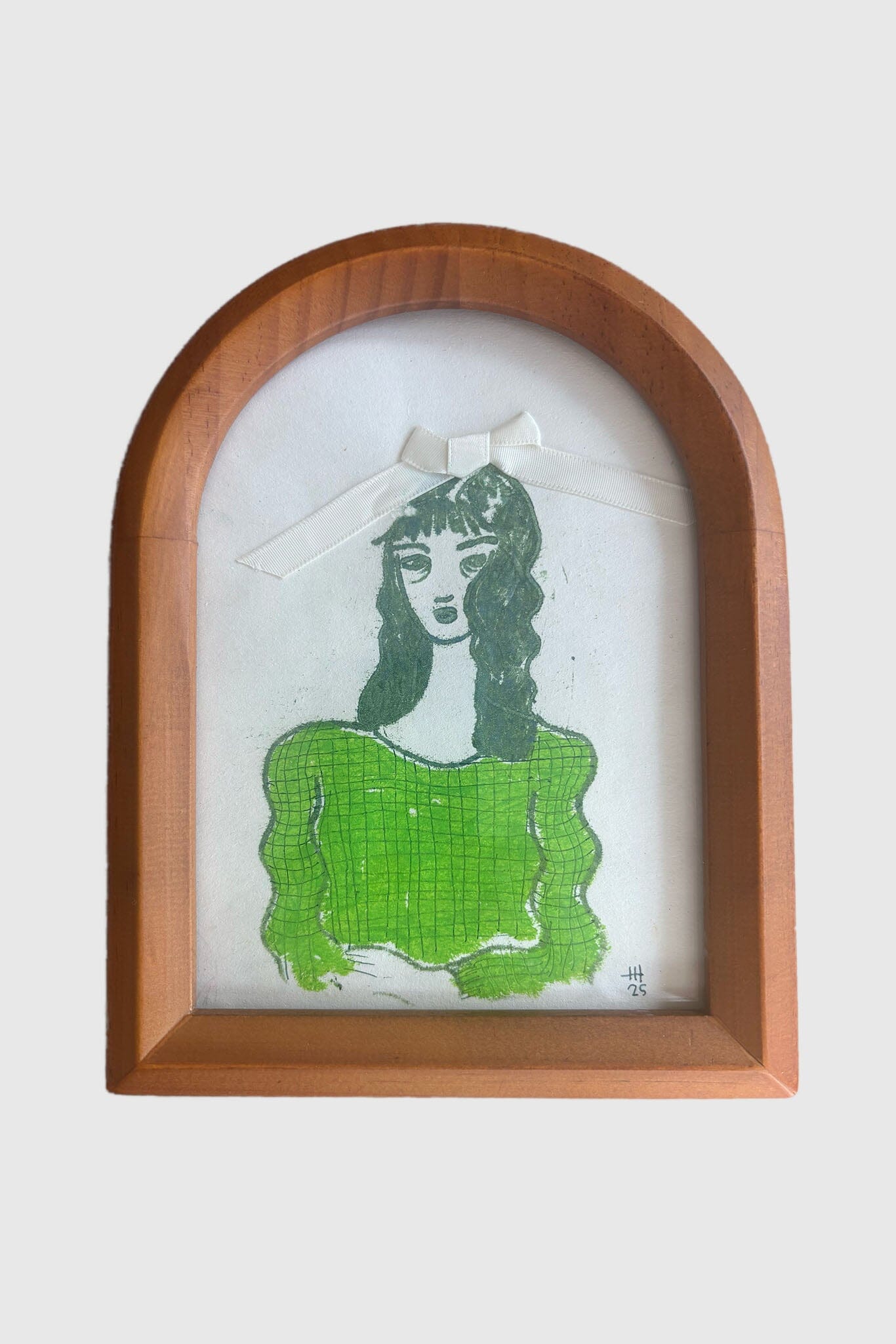 Framed artwork of a woman in a green dress with a white background