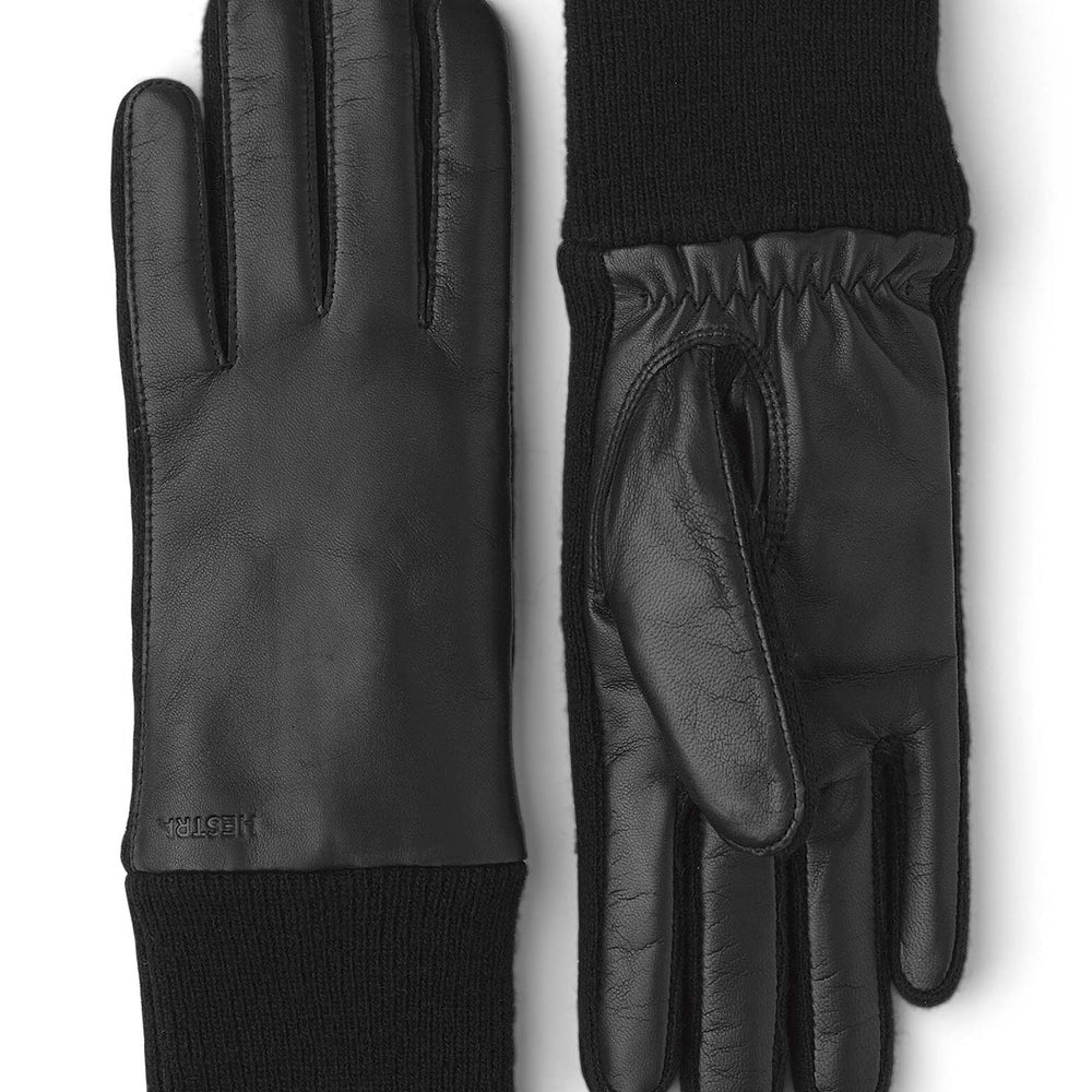 A pair of black gloves with elastic wrist cuffs and a knitted wool lining, made of leather and wool.
