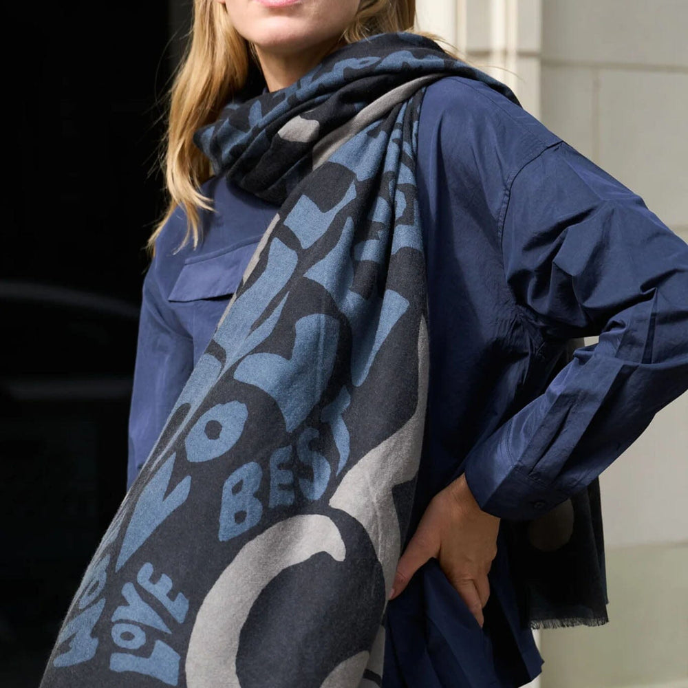 
                  
                    A woman wears the navy wool, silk and cashmere self love scarf
                  
                