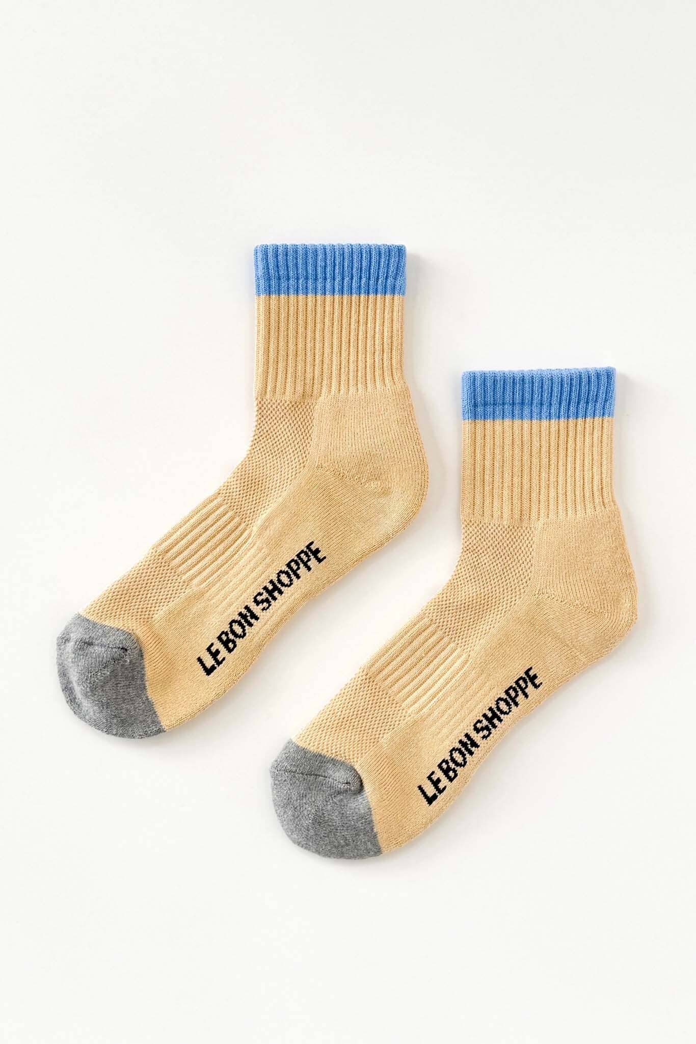 yellow socks with blue tops and gray toes, featuring 'Le Bon Shoppe' branding on a white background.