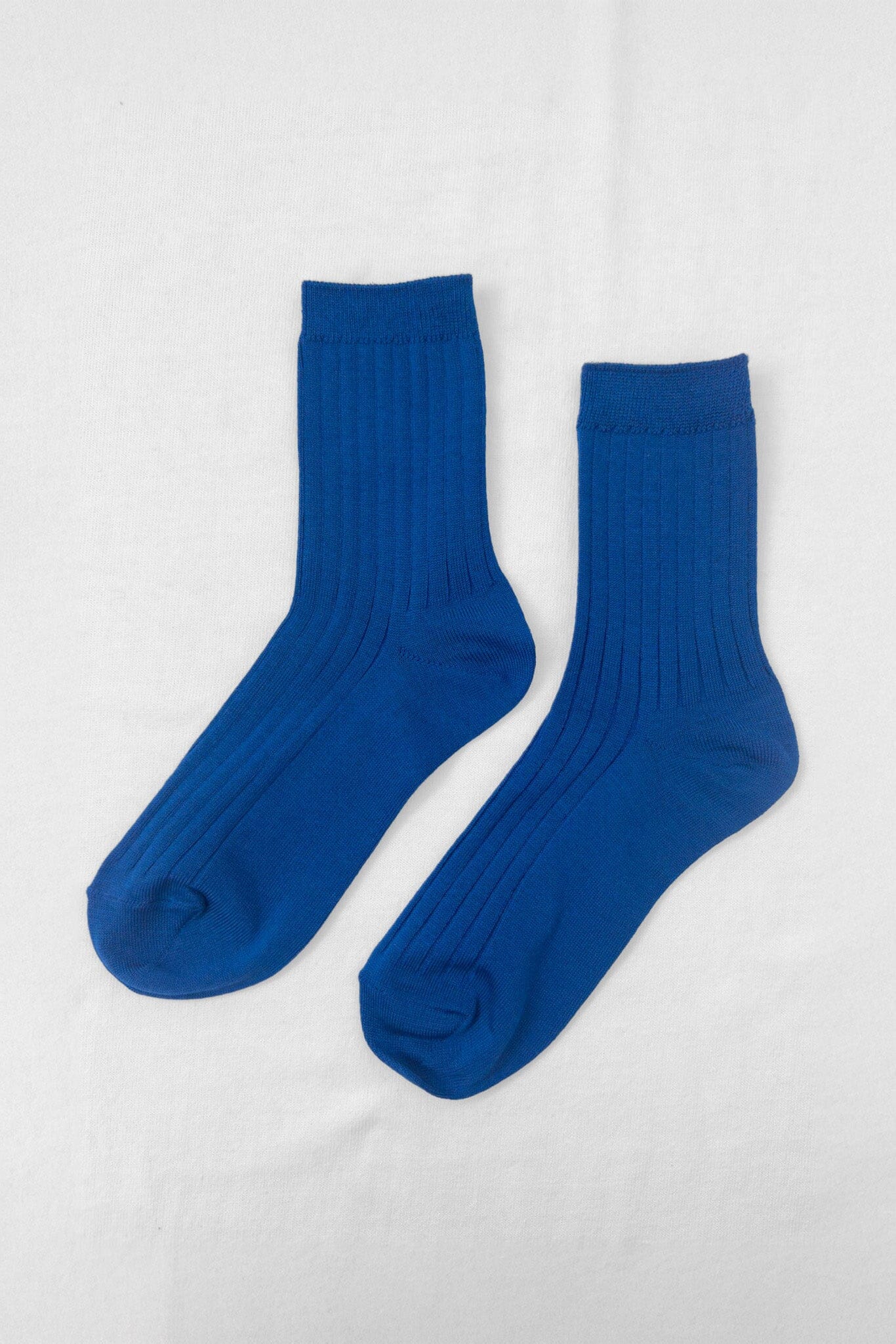 A pair of cobalt blue ribbed ankle socks displayed against a white background.